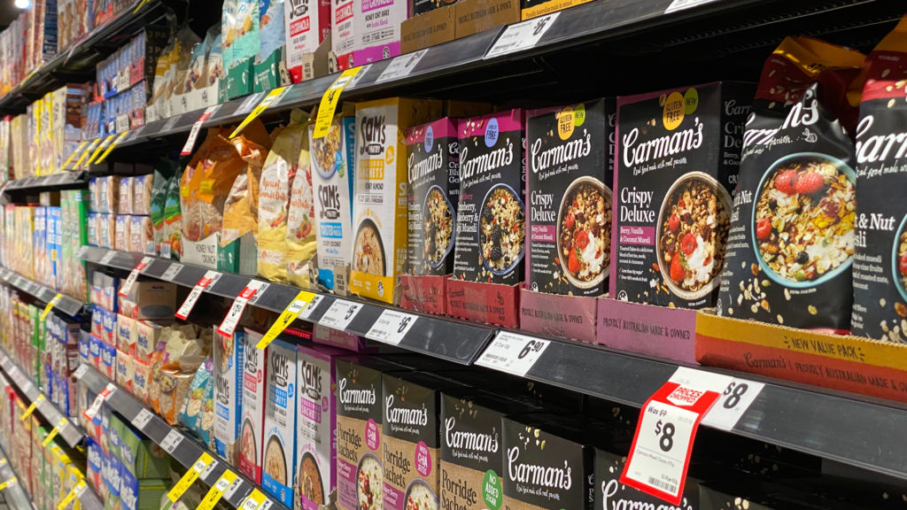 Supermarket shelf prominently featuring a variety of products packaged in cardboard, showcasing the industry's proactive shift and commitment to transitioning away from environmentally harmful plastic to more sustainable cardboard solutions